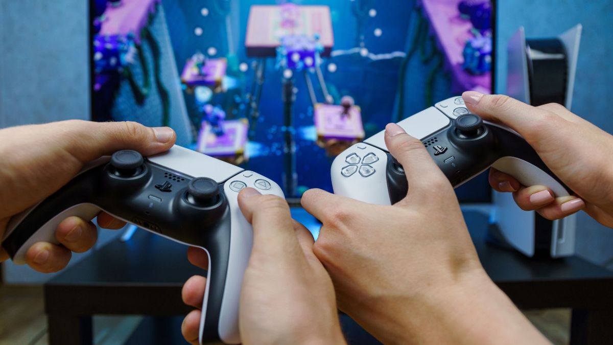 Zwei Personen halten PS5-Controller in der Hand und spielen.